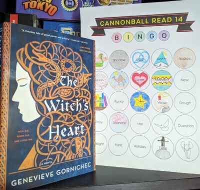 The book, "The Witch's Heart" by Genevieve Gornichec next to a book bingo card.