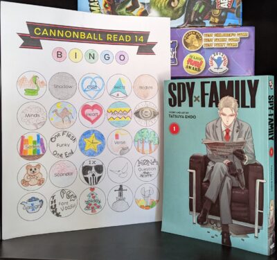 The manga, "Spy x Family volume one" by Tatsuya Endo standing next to a nearly complete book bingo card.