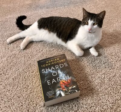 lounging cat with Shards of Earth book in foreground