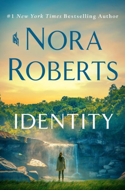 The cover of Nora Roberts' Identity. A casually dressed woman with a long dark brown ponytail stands in front of a misty waterfall cascading into a pool. 