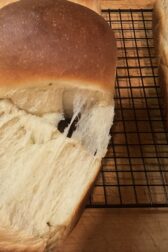 A picture of a milk bread loaf pulled apart to show the feathery texture of the bread. 