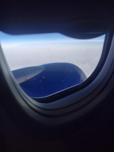 Plane window looking out onto engine. 