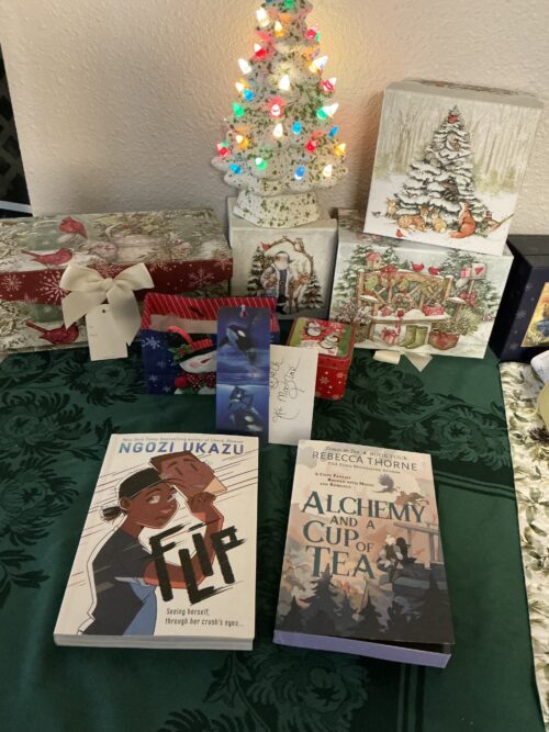 A table with a ceramic Christmas tree and two books on it