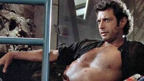 Jeff Goldblum as Dr. Ian Malcolm (Jurassic Park) lounges with his shirt unbuttoned 