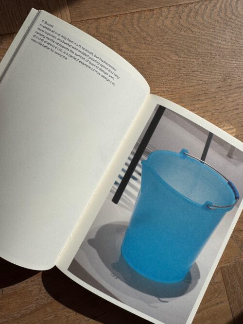 Page featuring a photo of a blue bucket. The description reads: "Available all over Italy from north to south, but mysteriously never exported, this bucket with molded pouring spout and easy carrying handle represents the summit of bucket design and, at a cost of about €1.50, is a perfect example of how design can make life better for everyone."